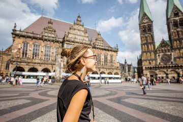 Young woman tourist enjoying great view on the city hall building and church in the centre of Bremen, Hamburg - obrazy, fototapety, plakaty