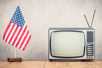 USA flag and retro TV set front old concrete wall background. Vintage instagram style filtered photo