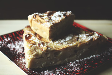 Homemade sweet apple pie with cinnamon and and powdered sugar.