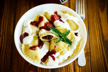 Homemade sweet dumplings with berries and sour cream