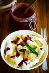 Homemade sweet dumplings with berries and sour cream