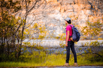 man traveling walking with backpack at national park in the jungle day time sun shine on holiday at weekend relax fresh on background nature view