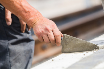 Construction worker working hard and leveling concrete pavement outdoors.