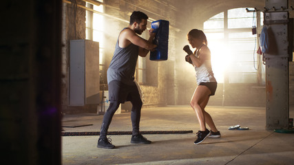Athletic Woman Hits Punching Bag that Her Partner/ Trainer Holds. She's Professional Fighter and is...