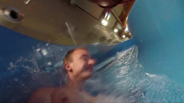 A man records himself sliding a water slide
