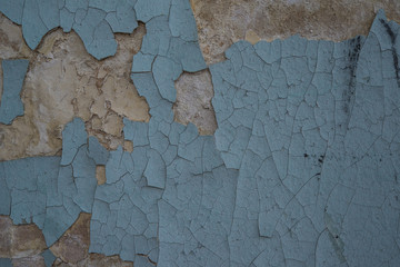 The cracked wall of the old building is blue