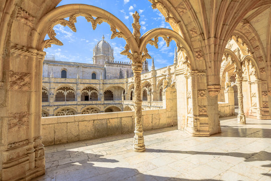 Beautiful reticulated vaulting on courtyard or cloisters of Hieronymites Monastery, Mosteiro dos Jeronimos, famous Lisbon landmark in Belem district and Unesco Heritage. Church dome on background.