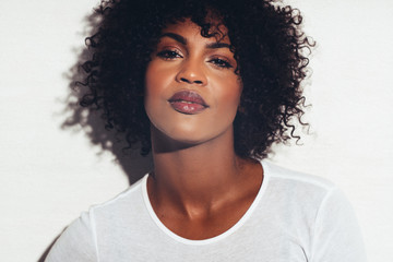 Attractive African woman with attitude standing against a white