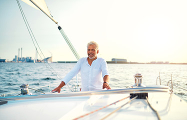 Mature man standing on the deck of his sailboat