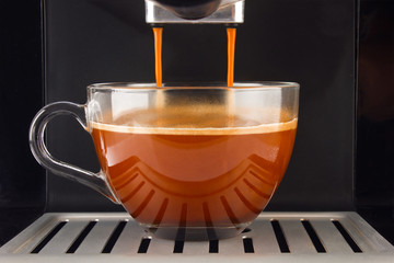 Fresh coffee prepared in the machine. Espresso glass cup. Stock