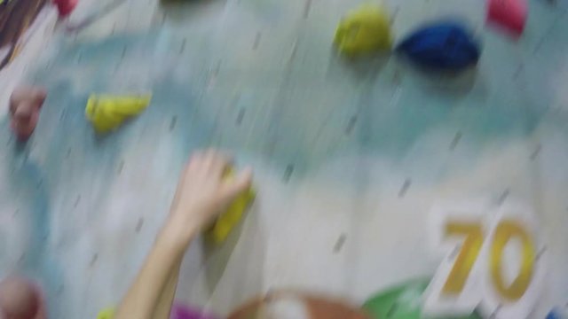 POV GoPro - a man climbs on a colorful training wall