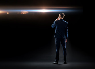 businessman over black looking at laser light
