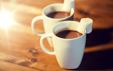 cups of hot chocolate with marshmallow on wood