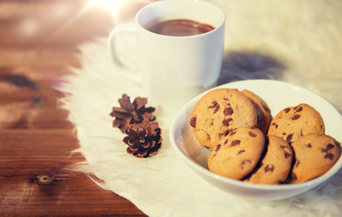 cups of hot chocolate with cookies on fur rug