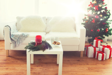 sofa, table and christmas tree with gifts at home