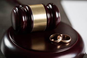 Divorce concept with gavel and wedding rings