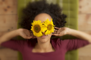 Junge Frau mit Sonnenblumen auf den Augen