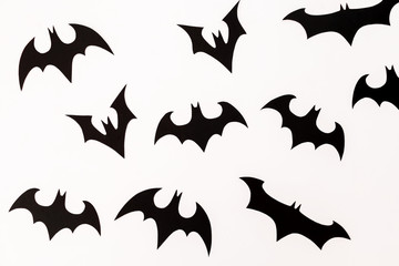Pattern of handmade black paper bats for Halloween holiday on white background. Flat lay, top view.