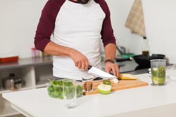 man with blender and fruit cooking at home kitchen