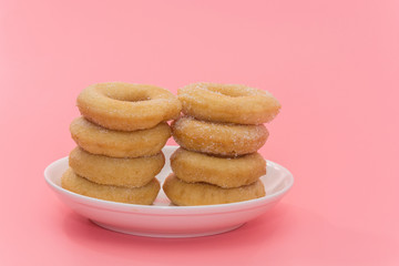 Fried Donuts with sugar topping on pink background