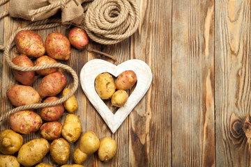 Raw potatoes on a wooden background
