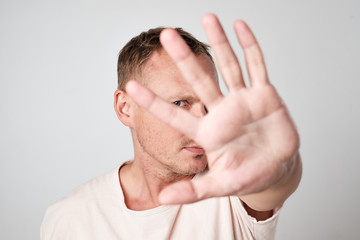Fototapeta premium Young Caucasian man hiding his face with hand