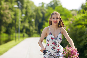 happy woman riding fixie bicycle in summer park