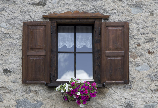 Fototapeta Window with open wooden shutters and flowers
