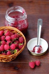 Raspberries and raspberry jam in a wooden basket  