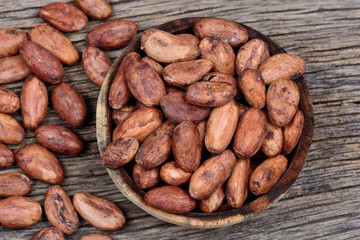 Cacao beans in a bowl on rustic table