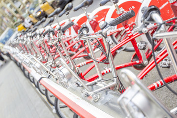 Bicycles stand in a row on a parking for rent.