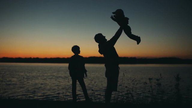 Father and son playing in the park at sunset silhouette of a happy family