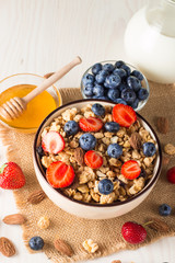 Healthy breakfast concept with oat flakes and fresh berries on rustic background. Food made of granola, muesli. Healthy banana smoothie with blackberries, muslie, strawberries, blueberries and honey.