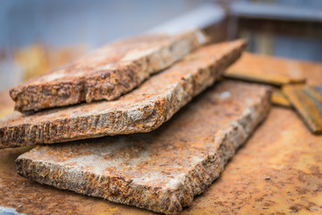 The rusty pieces of metal on a metal table.