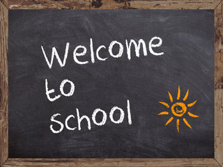 Welcome to school written on a blackboard with wooden frame