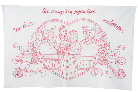 Vintage redwork embroidery kitchen towel. It has written on it For one hot kiss I would give you my whole life, in the Serbian language, in Cyrillic. Isolated on white background. Working path saved.