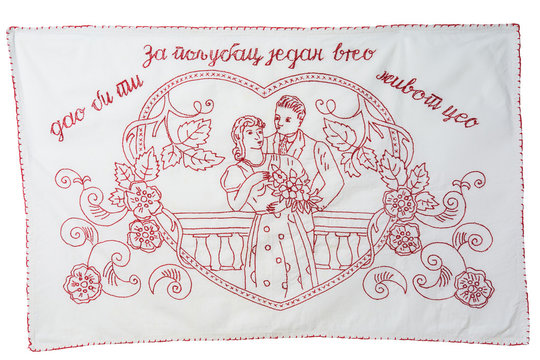 Vintage redwork embroidery kitchen towel, red-bordered. It has written on it For one hot kiss I would give you my whole life, in the Serbian language. Isolated on white background. Working path saved.