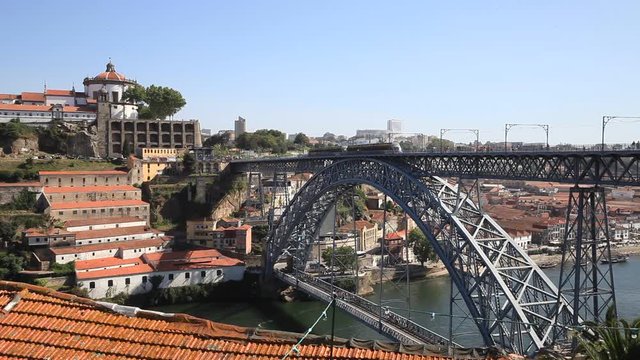 Iron bridge in Porto with view of the river and rooftops with metro passing by