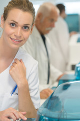 Obraz premium nurse assistant with white coat smiling at camera