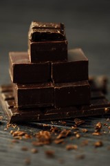 Delicious black and milk chocolate on a brown background 
