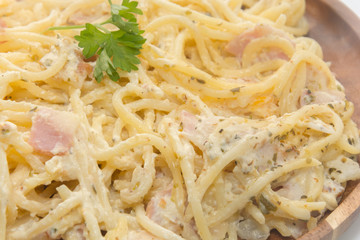 spaghetti carbonara with cream on wooden plate on white background