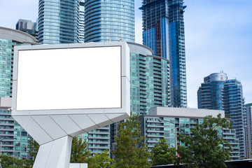 blank billboard in front of tall office and apartment buildings in a city