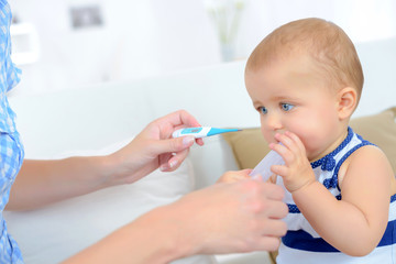 woman taking babys temperature