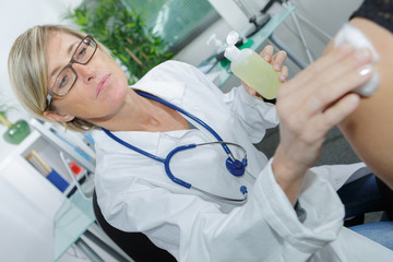 female doctor disinfecting patient before vaccination