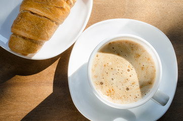 Cappuccino or coffee latte and croissant.
