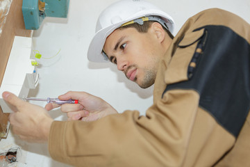 builder with screwdriver fixing socket indoors