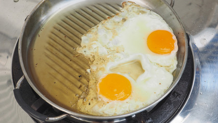 Close up photo cooking 2 hen eggs fried with sesame seeds