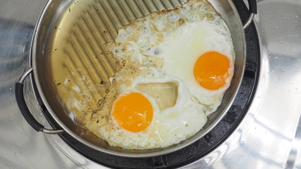 Cooking 2 hen eggs fried in stainless steel pan and clipping paths