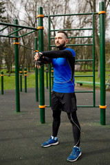 Obraz premium Young strong man stretches his muscles before training