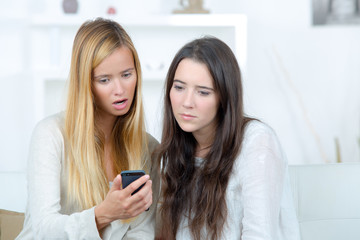 woman showing something on the phone to her friend